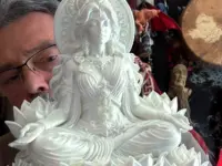 White Parvati goddess statue seated on a lotus base with an ornate halo